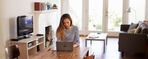 Woman working remotely from home at her dining table
