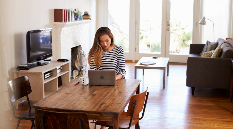 Woman working remotely from home at her dining table